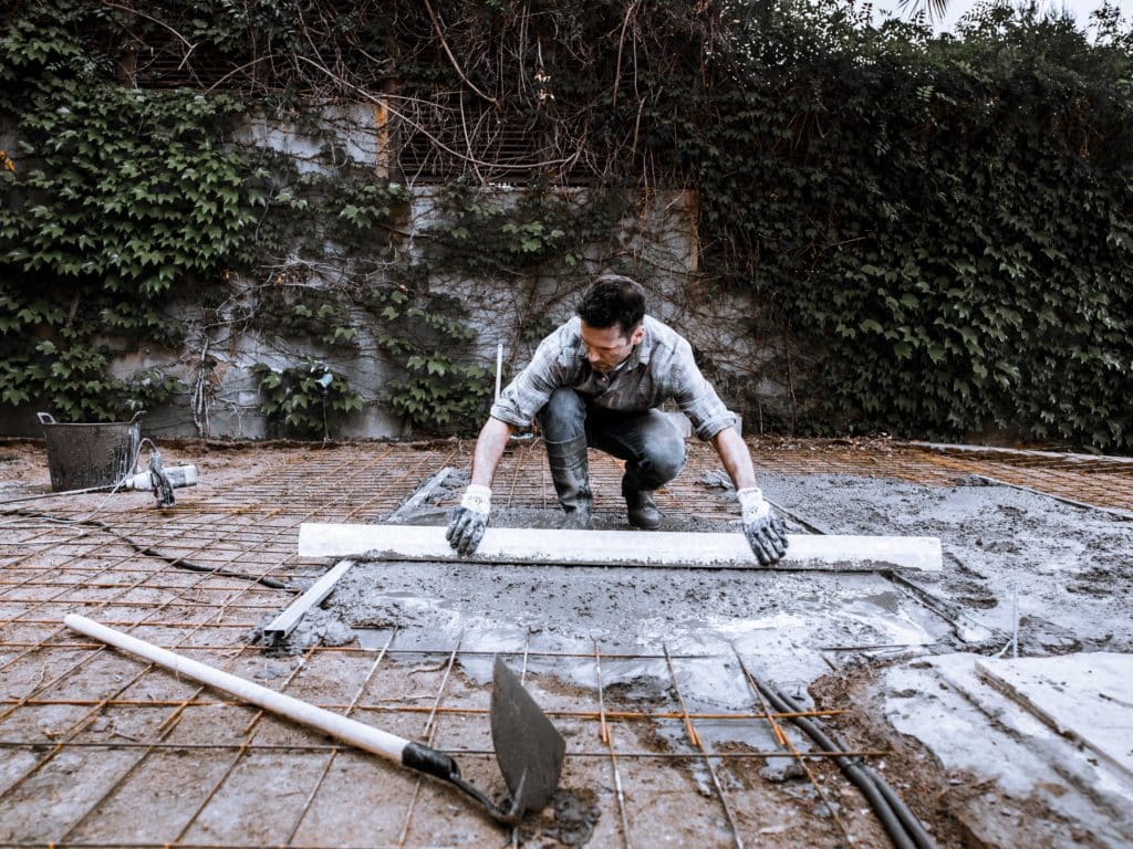 Man smoothing concrete in construction site.