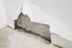 Damaged wall with visible cracks and chipped paint.