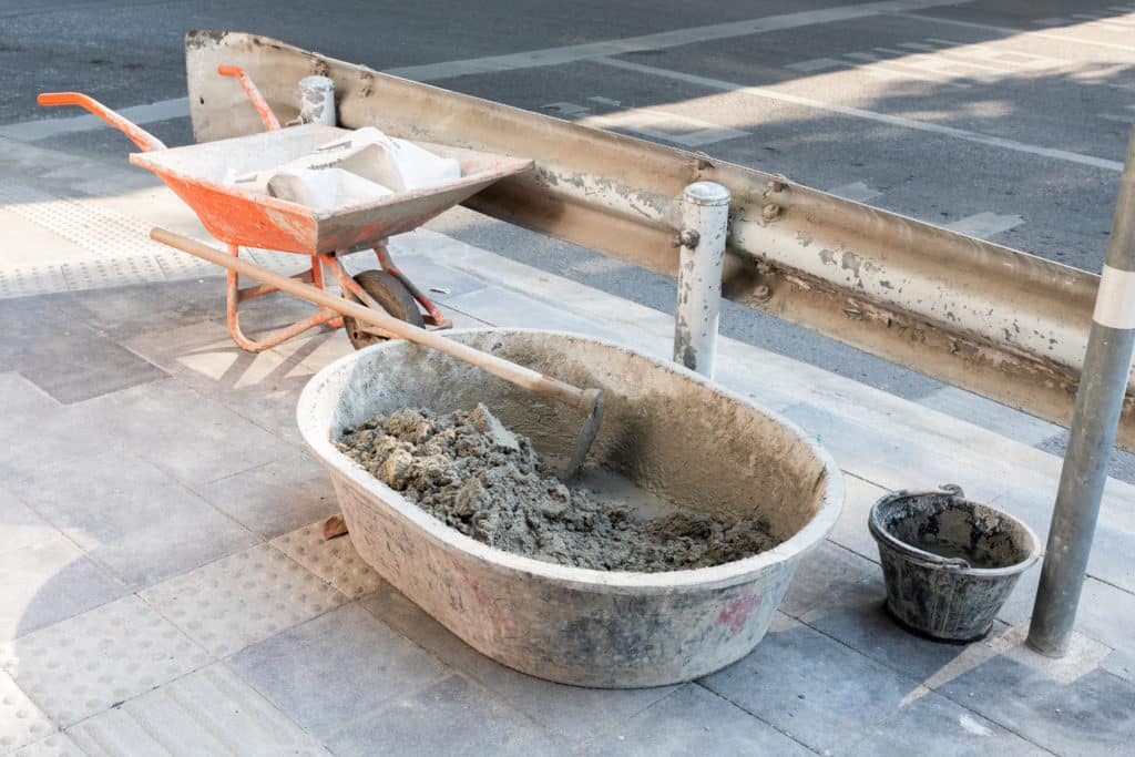 Construction wheelbarrow and cement mixing tools on site.