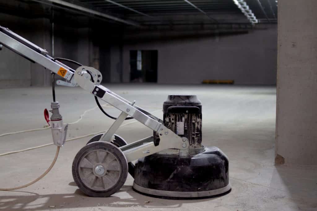 Floor polishing machine in empty concrete building.