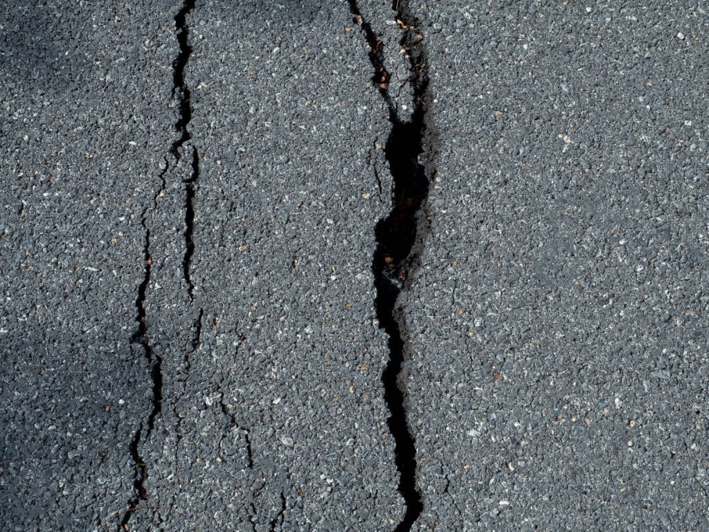 Cracked asphalt texture close-up.