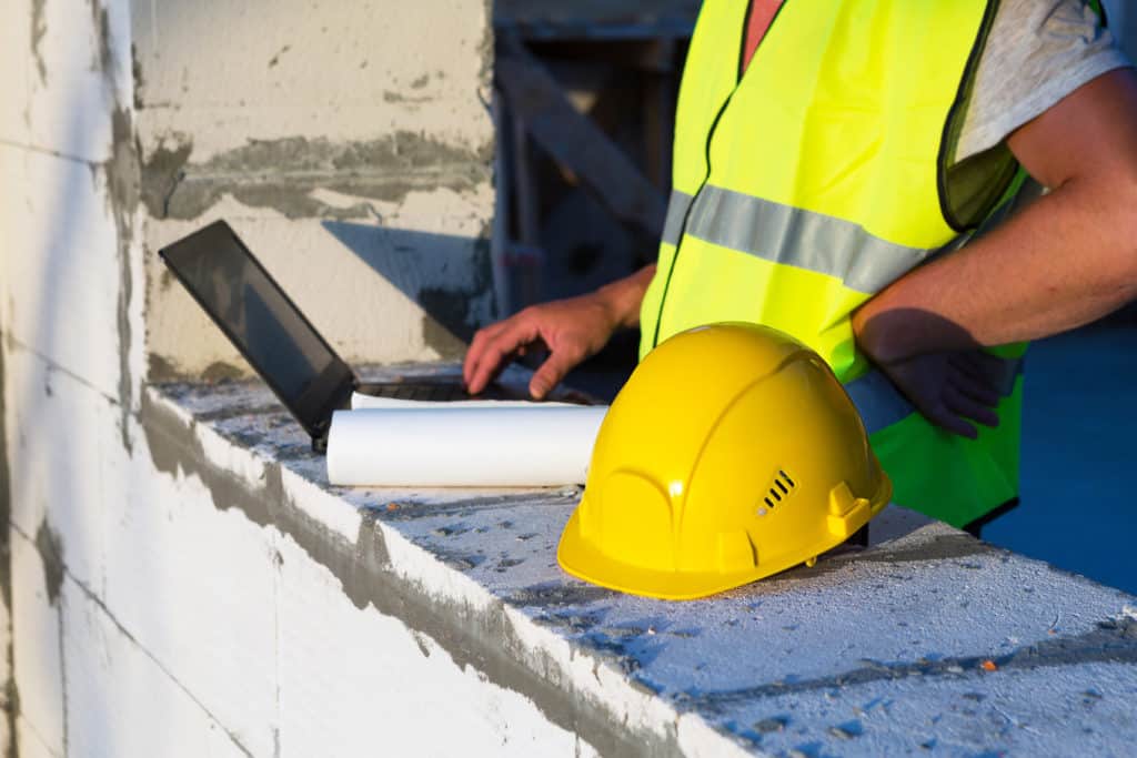 Construction worker using laptop at site