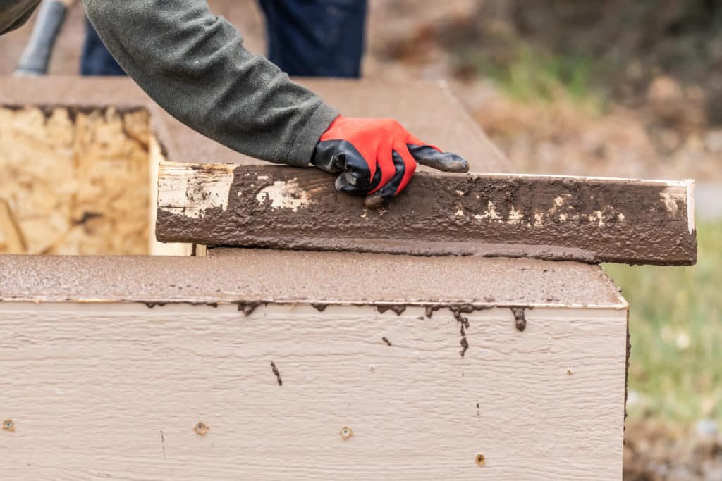 Person carrying wood plank for construction.