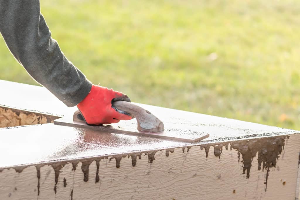 Carpenter hammering a nail outdoors.