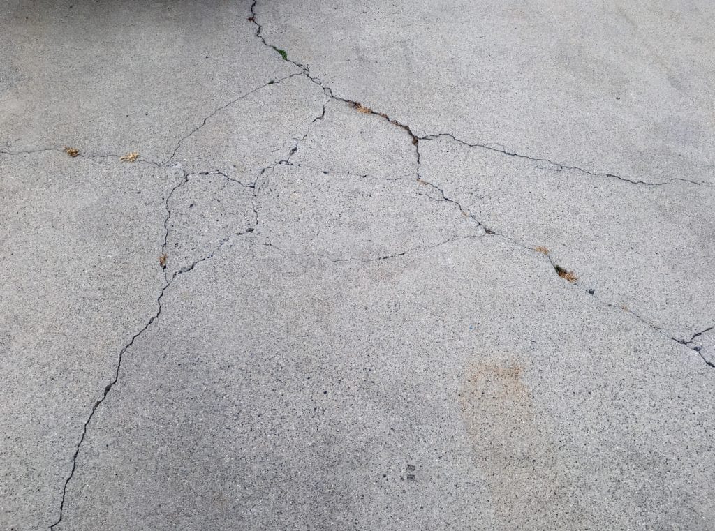 Cracked concrete pavement with visible damage.