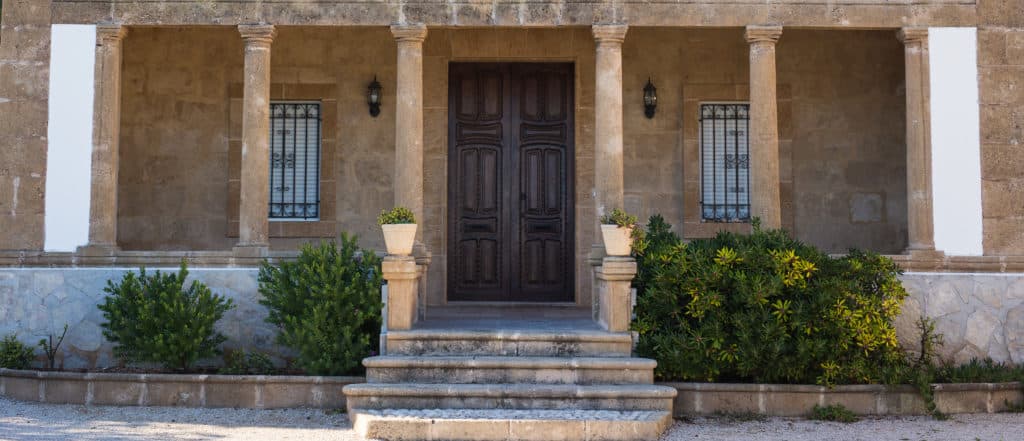 Stone facade with wooden door and potted plants