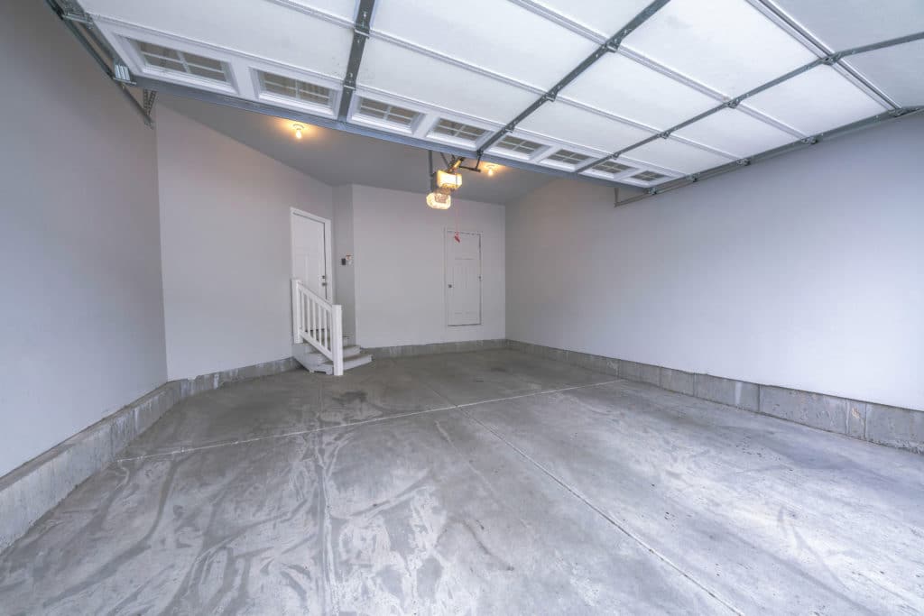 Empty two-car garage interior with open door.