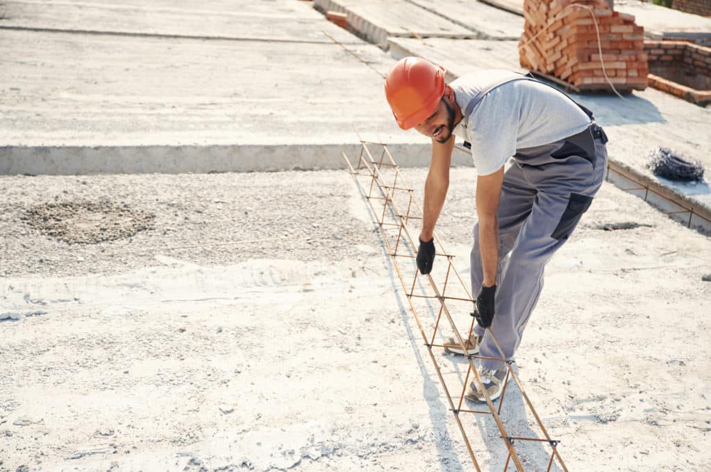 Construction worker installing rebar on site