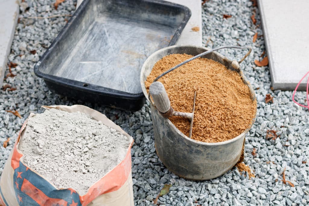 Construction materials: cement, sand, and wheelbarrow.