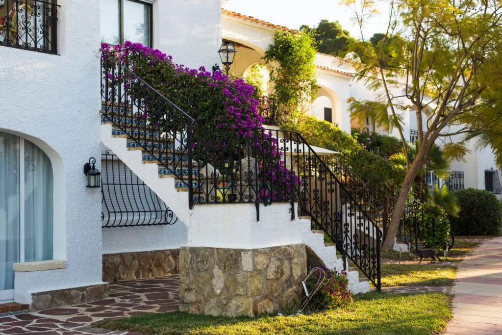 Traditional villa with bougainvillea and iron staircase.