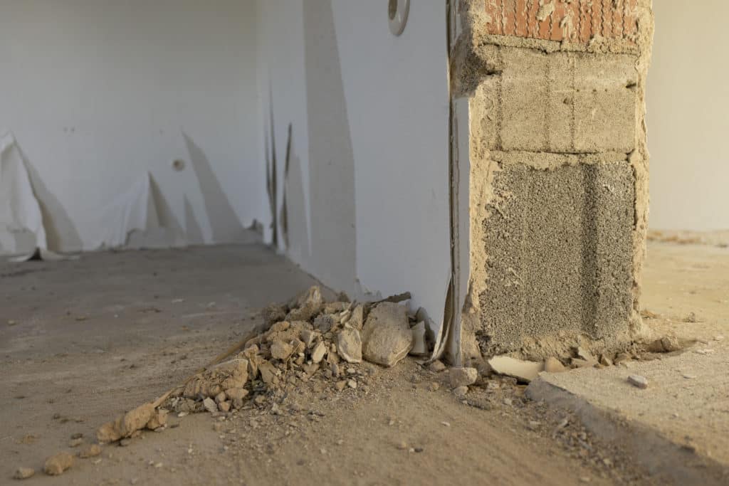 Construction debris near damaged interior wall