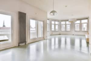 Spacious empty room with large windows and natural light.