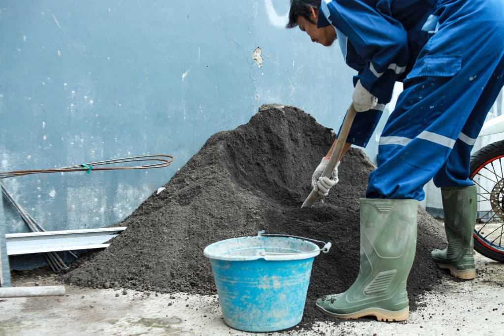 Worker shoveling gravel at construction site