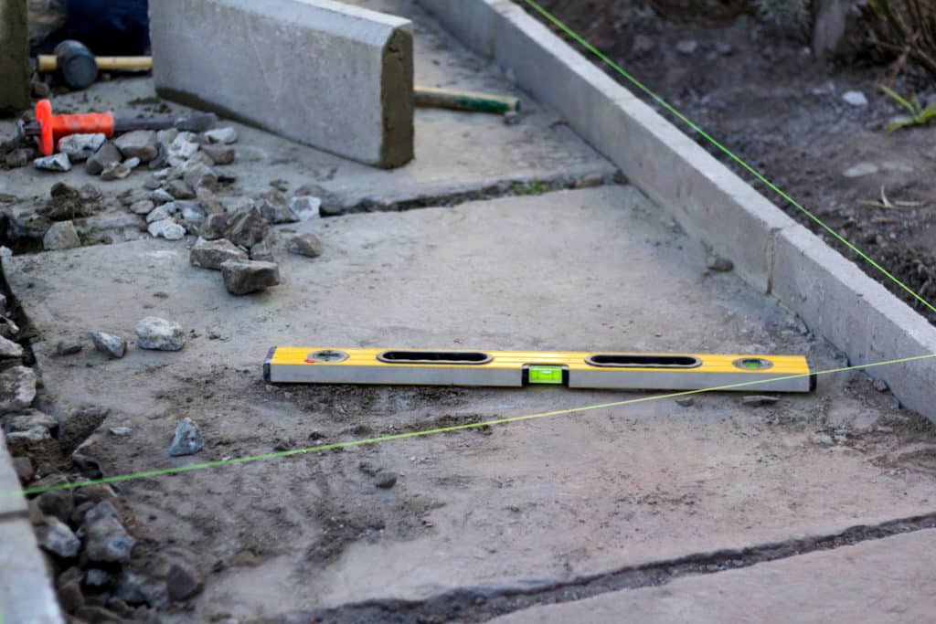 Level tool on new concrete foundation construction site.