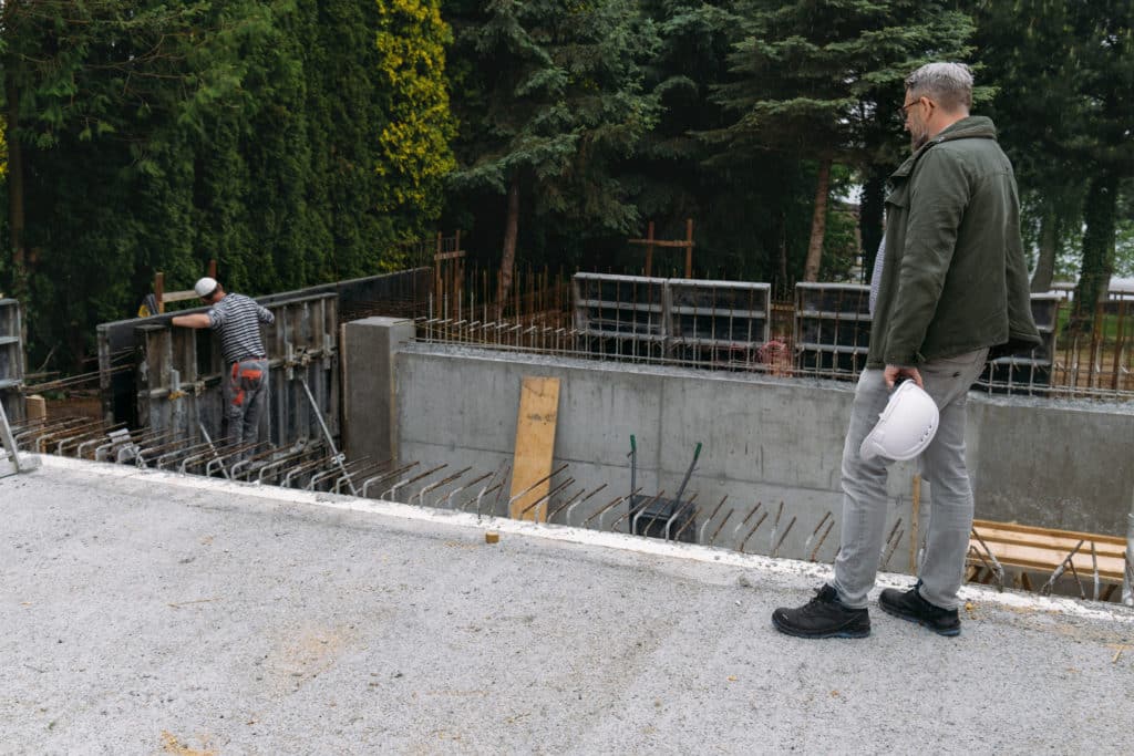 Man observing construction site with workers.