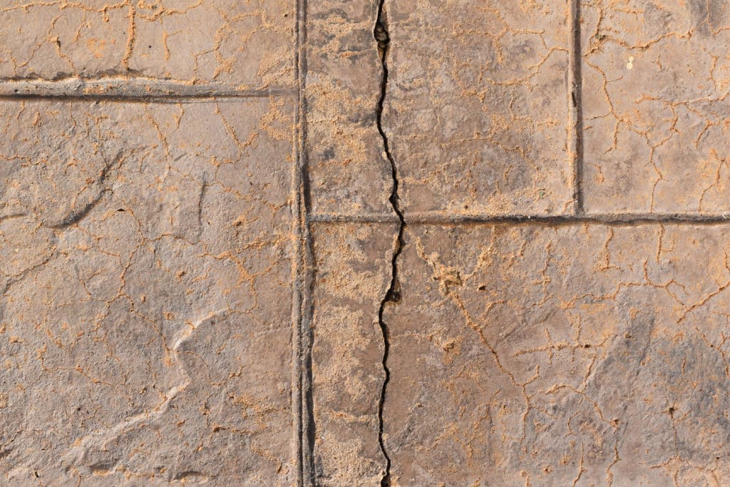 Cracked brown stone tiles texture.