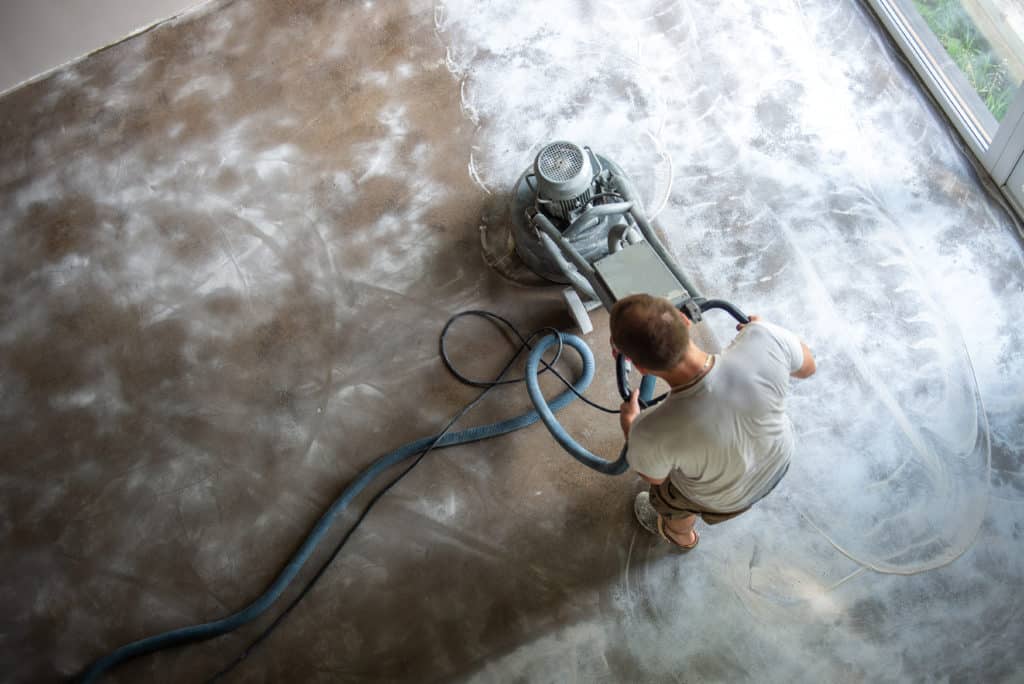 Man operating floor buffering machine indoors.