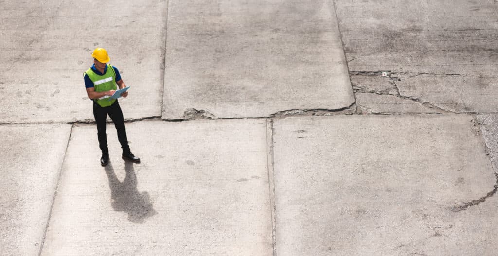 Construction worker with clipboard on concrete site.