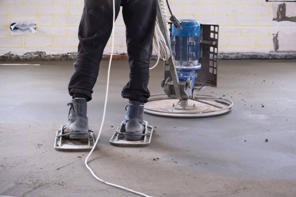 Person using concrete floor polishing machine.