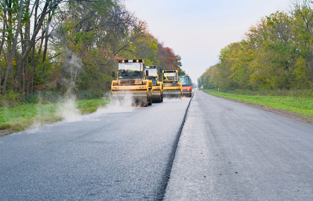 Road construction with asphalt paving machines.