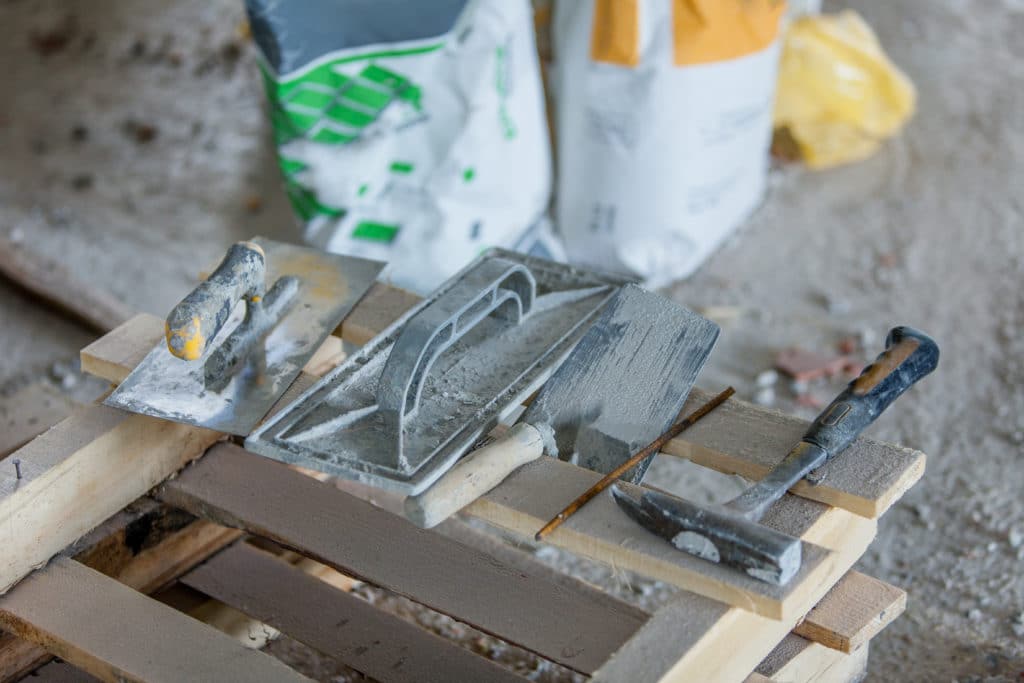 Construction tools on wooden pallet at worksite.