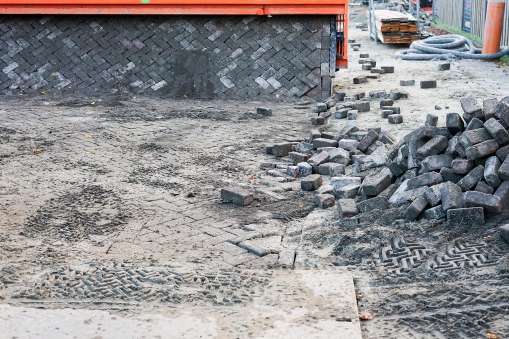 Street under construction with cobblestones and dirt.