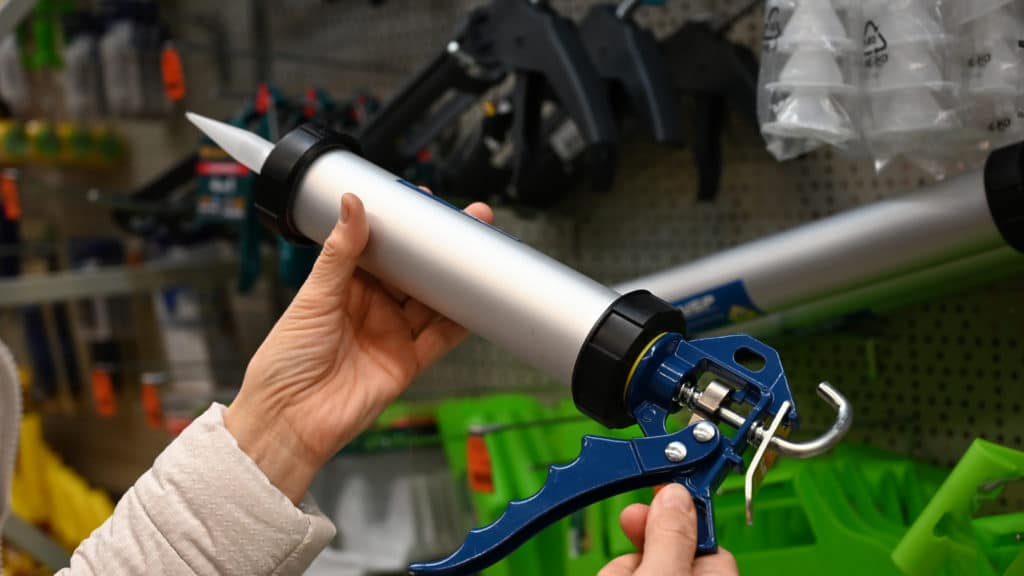 Caulking gun in hardware store aisle.