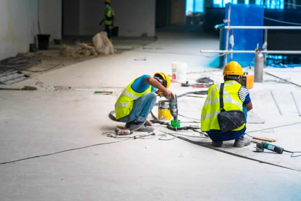 Construction workers drilling on site.