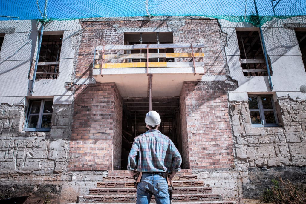 Worker inspecting construction site entrance.