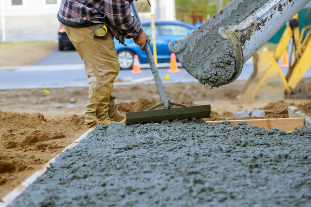 Worker leveling concrete at construction site