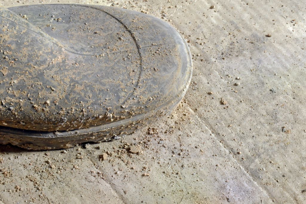 Muddy basketball on concrete surface.