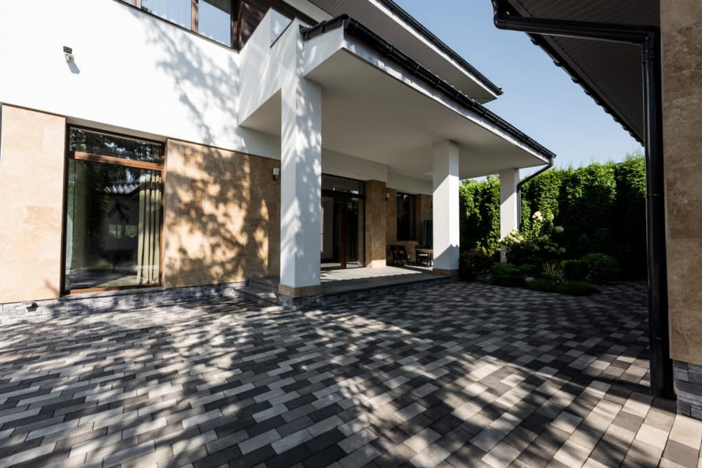 Modern house exterior with patio and herringbone pavers.