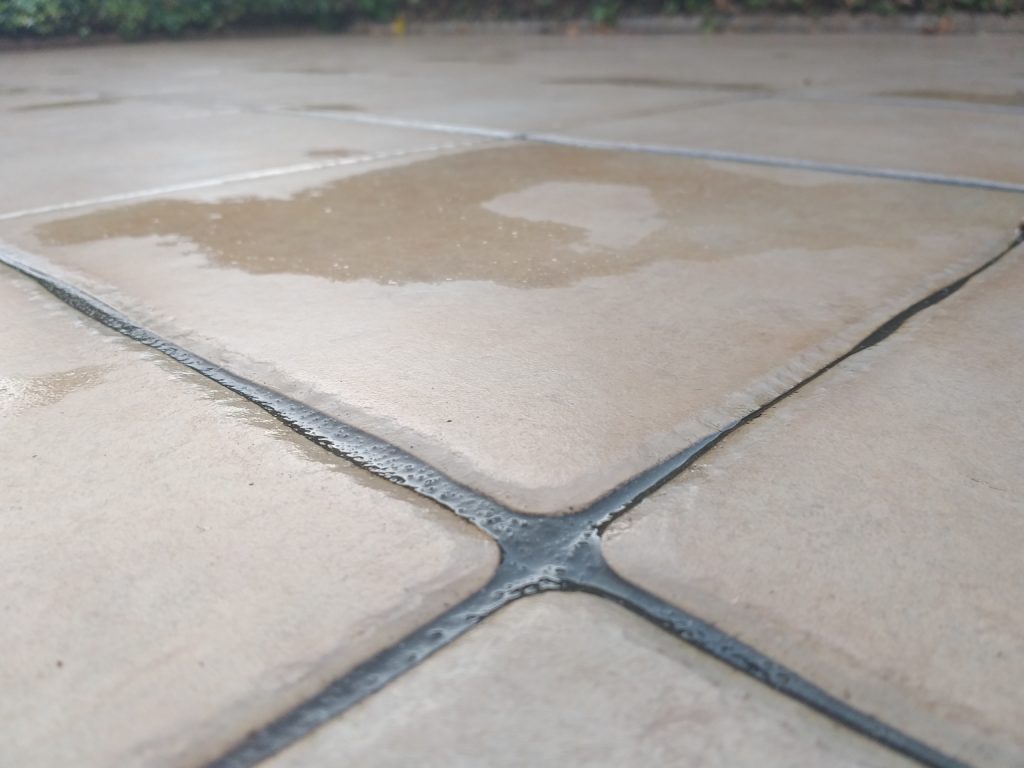 Wet outdoor tiles after rain, close-up view.