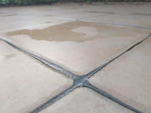 Wet outdoor tiles after rain, close-up view.