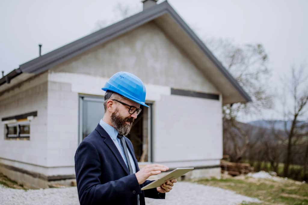 Architect inspecting construction site with tablet.