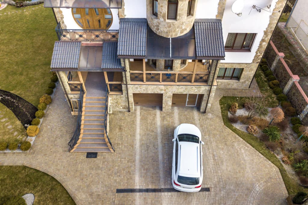 Luxury house exterior with car, aerial view.