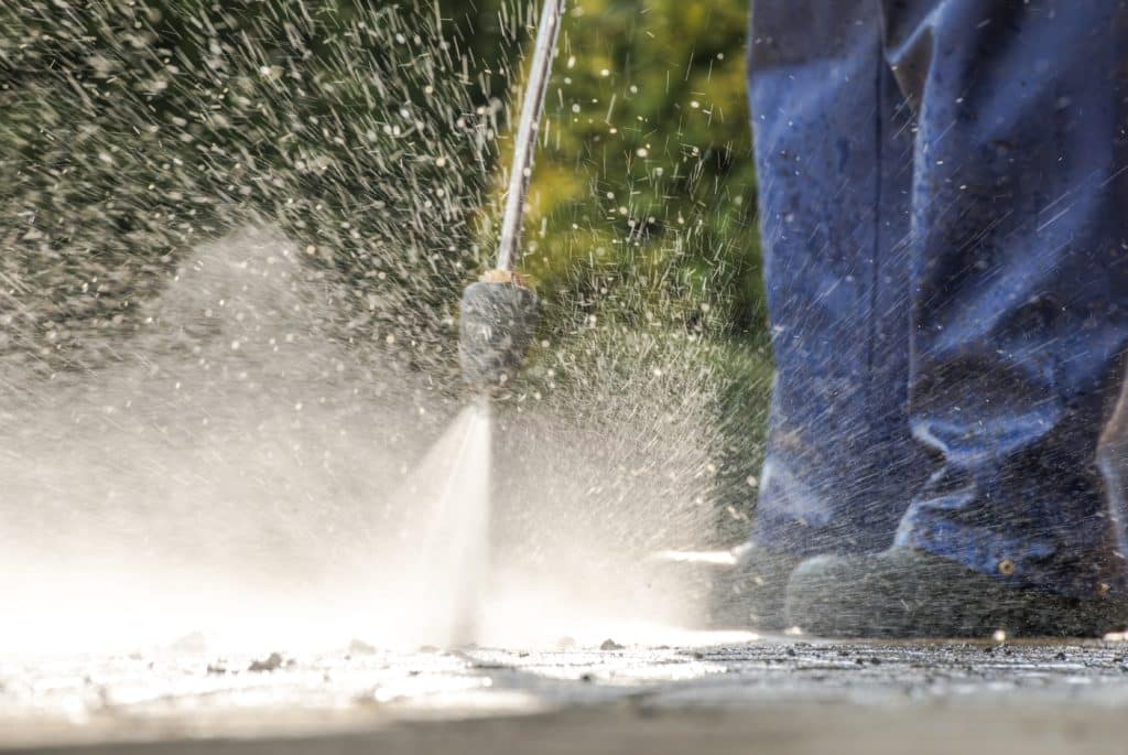 Pressure washing pavement outdoors.