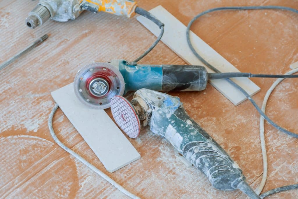 Construction tools covered in dust on floor.