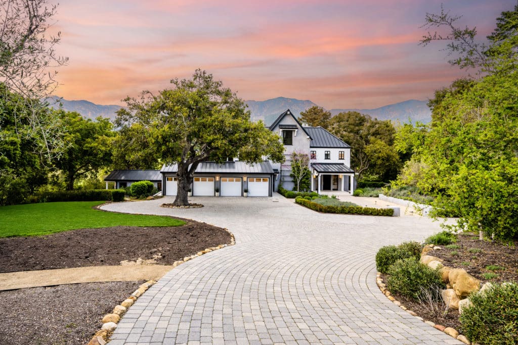 Luxury home driveway at sunset with mountains background.