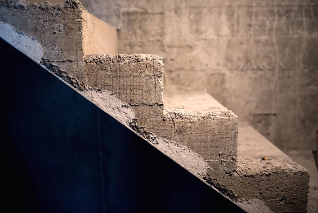 Concrete staircase with textured steps and shadow.