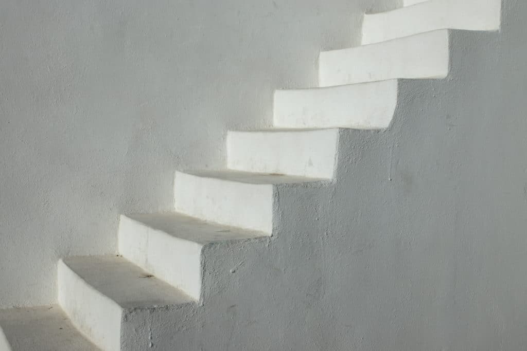 White minimalist outdoor staircase on gray wall.